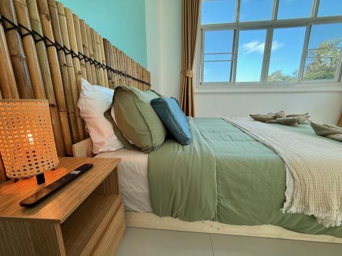 Un dormitorio con una cama y una mesa y una ventana. en Coastal Nomad Ocean View Stay - 1 or 2 Rooms, en Ban Pak Khlong Phe