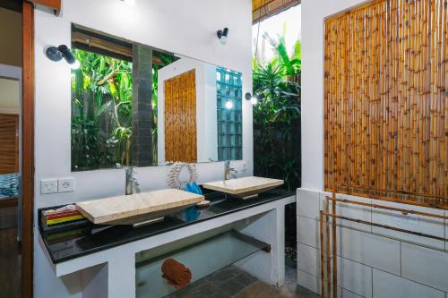 a bathroom with two sinks and a mirror at Villa Moringa 2 - Private Villa in the Heart of Canggu, 5 Minutes from the Beach in Canggu