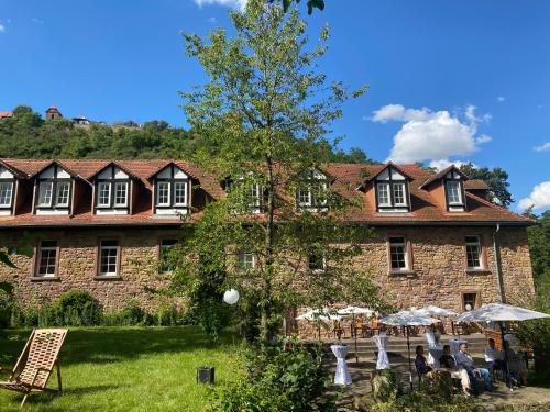 a large stone building with people sitting in front of it at Felsenmühle Neuleiningen in Neuleiningen