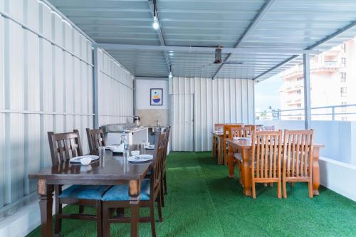 a dining room with wooden tables and chairs at Treebo Emirates Suites Indiranagar in Bengaluru