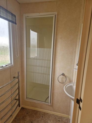 a glass shower in a bathroom with a sink at I love Costinesti in Costinesti