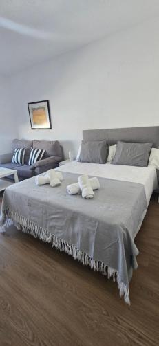 una camera da letto con un letto grande con asciugamani sopra di Triana Apartahotel a Siviglia
