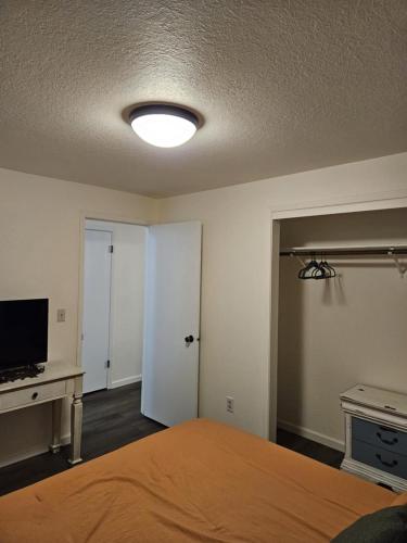 a bedroom with a bed and a television and a door at There's No Place Like Home in Garden City