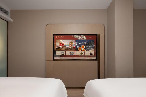a room with two beds and a flat screen tv at Chengdu Echeng Hotel Chunxi Road Taikoo Li in Chengdu