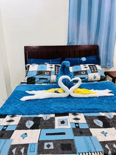 a bed with two swans laying on it at M and M Apartment in Surigao