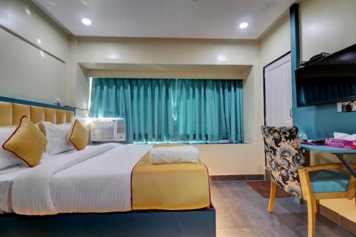 a bedroom with a bed and a desk and a chair at Hotel Platinum Inn in Navi Mumbai