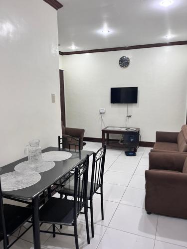 a living room with a table and chairs and a couch at M and M Apartment in Surigao