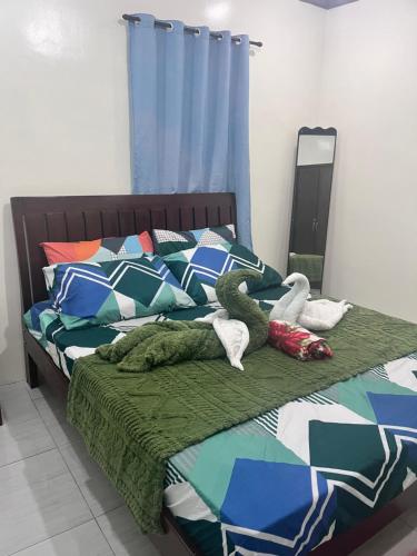 a bed with two stuffed animals laying on it at M and M Apartment in Surigao