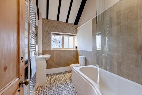 Dale View Cottages and Rooms - Whitby في Stainsacre: حمام مع حوض استحمام ومرحاض ومغسلة