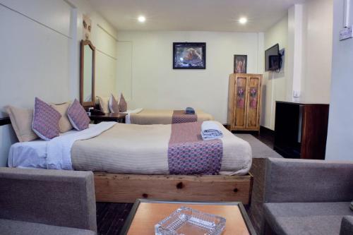 a bedroom with a bed and a couch at Hotel Shree Tara in Kathmandu