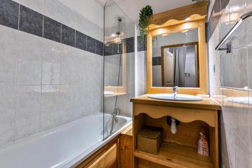 une salle de bain avec une baignoire, un lavabo et un miroir dans l'établissement Résidence Les Hauts De Preclaux - Appartement 2 pièces au coeur des Orres 1800 MAE-3411, aux Orres