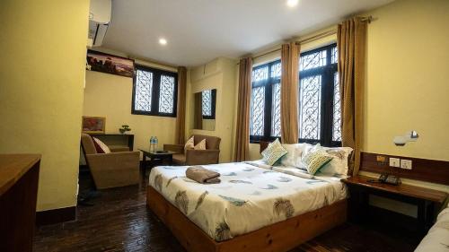 a bedroom with a large bed in a room with windows at Hotel Shree Tara in Kathmandu
