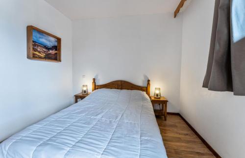 - un lit dans une chambre avec 2 tables de chevet dans l'établissement Résidence Les Hauts De Preclaux - Appartement au coeur des Orres 1800 MAE-4471, aux Orres