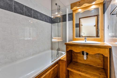une salle de bain avec un lavabo, une baignoire et un miroir dans l'établissement Résidence Les Hauts De Preclaux - Appartement au coeur des Orres 1800 MAE-4471, aux Orres