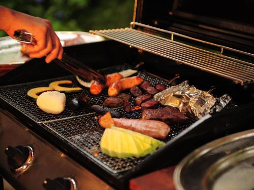 a person is cooking food on a grill at Izumigo AMBIENT Azumino Cottage in Azumino