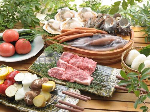 a table topped with different types of seafood and vegetables at Izumigo AMBIENT Azumino Cottage in Azumino