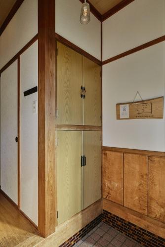 an empty room with wooden cabinets and a door at 民泊あまやど Amayado in Owase