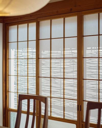a dining room with large windows and two chairs at 民泊あまやど Amayado in Owase