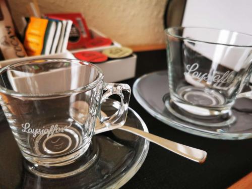 two glass cups sitting on a table with plates at Best Western Macrander Hotel Frankfurt/Kaiserlei in Offenbach