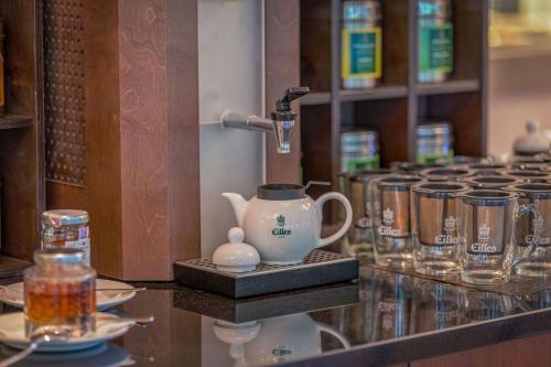 a counter with a tea pot and glasses on it at Best Western Macrander Hotel Frankfurt/Kaiserlei in Offenbach