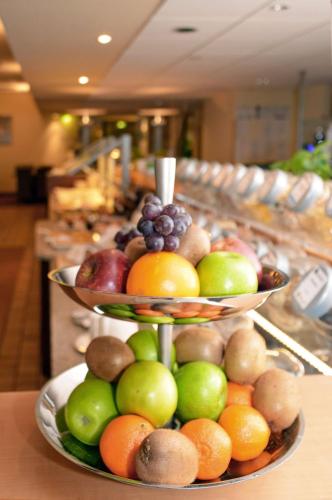 two tiers of fruit on plates on a buffet at Best Western Macrander Hotel Frankfurt/Kaiserlei in Offenbach