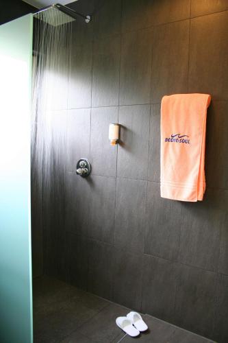 a shower with an orange towel on a wall at Best Western Macrander Hotel Frankfurt/Kaiserlei in Offenbach