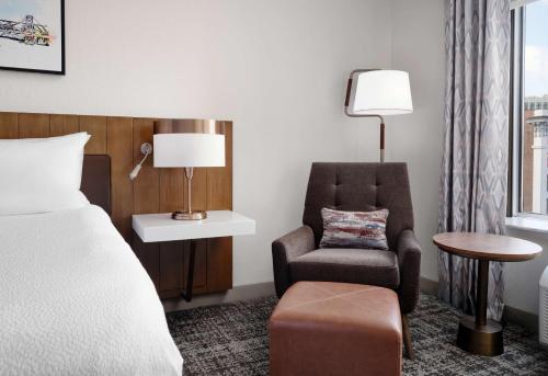 a hotel room with a bed and a chair at Hilton Garden Inn Detroit Downtown in Detroit