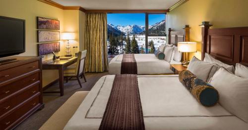 a hotel room with two beds and a desk and a television at Everline Resort and Spa, Lake Tahoe in Olympic Valley