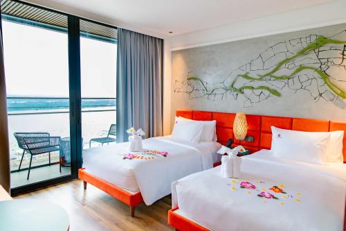 two beds in a hotel room with a view at CENTRAL PLAZA HOTEL - Mỹ Tho in My Tho