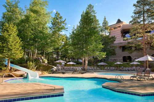 a pool at a resort with chairs and umbrellas at Everline Resort and Spa, Lake Tahoe in Olympic Valley