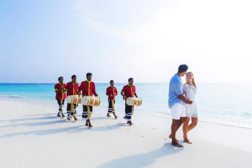a group of children playing drums on the beach at Dusit Thani Maldives - 50 percent discount on transfers for stays until 20 Dec 2025 in Baa Atoll