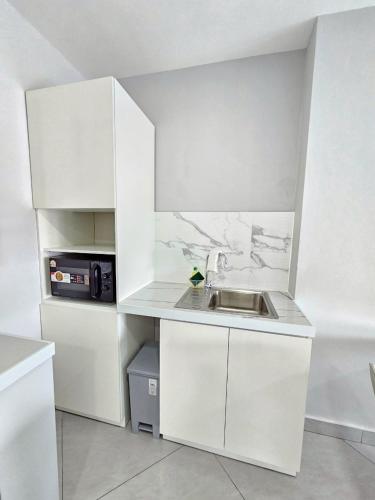 a white kitchen with a sink and a microwave at View Talay6 by Blue Ocean Suite in Pattaya Central
