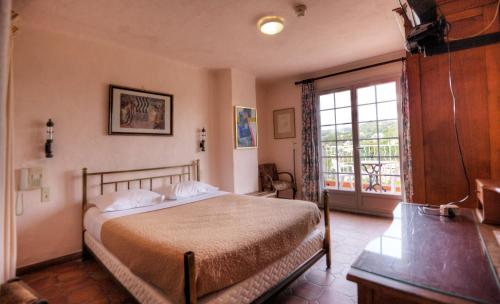 Ένα ή περισσότερα κρεβάτια σε δωμάτιο στο Hôtel Les Arcades