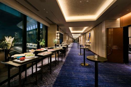 a row of tables in a room with windows at Hilton Yokohama in Yokohama