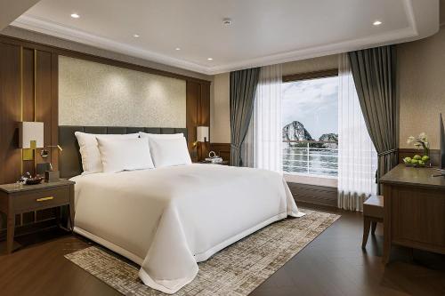 a bedroom with a large white bed and a window at Paradise Legacy Cruise Halong in Ha Long