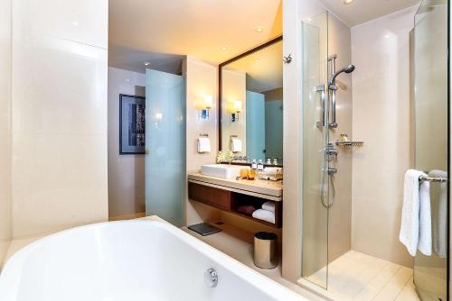 バンコクにあるヒルトン バンコク グランデ アソーク - Hilton Bangkok Grande Asokeのバスルーム(バスタブ、シャワー、シンク付)