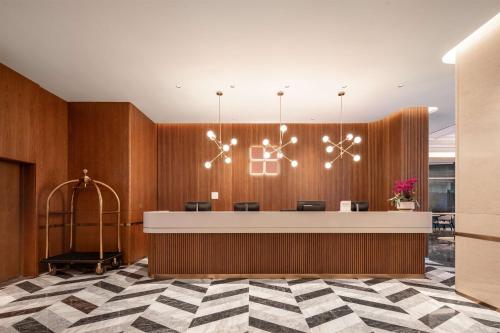 a lobby with a reception desk with a chandelier at Hilton Garden Inn Suzhou Kunshan in Suzhou