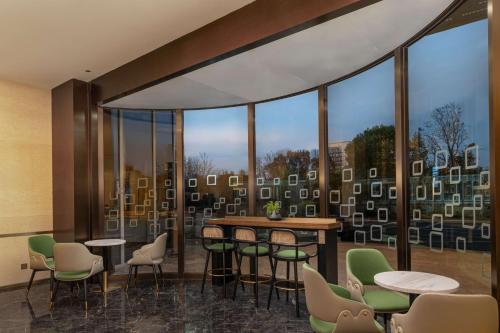 a room with tables and chairs and a large window at Hilton Garden Inn Suzhou Kunshan in Suzhou