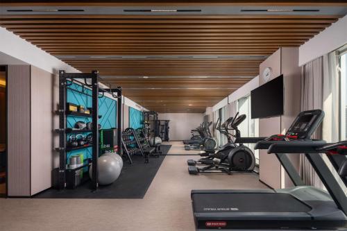 a gym with treadmills and cardio equipment in a room at Hilton Garden Inn Suzhou Kunshan in Suzhou