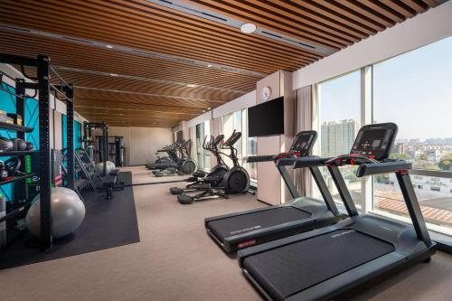 a gym with treadmills and cardio equipment in a building at Hilton Garden Inn Suzhou Kunshan in Suzhou