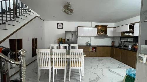 a kitchen with a table and chairs and a staircase at Flower homestay in Thôn Dương Xuân Hạ