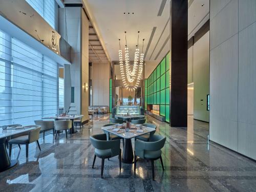 a restaurant with tables and chairs and a chandelier at Doubletree By Hilton Yanji in Yanji
