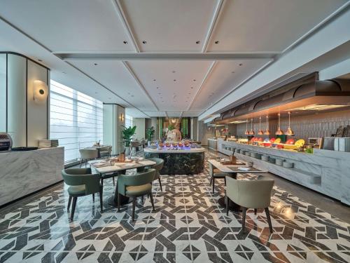 a restaurant with tables and chairs in a room at Doubletree By Hilton Yanji in Yanji