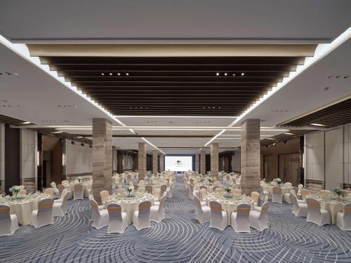 a large banquet hall with white tables and chairs at Doubletree By Hilton Yanji in Yanji