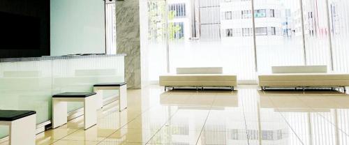 a lobby with two benches and a large window at Hotel Oriental Express Nagoya Sakae in Nagoya