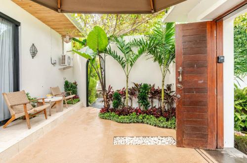 ジンバランにあるKarma House Ungasanの植物のあるパティオへとつながる開放的なドア