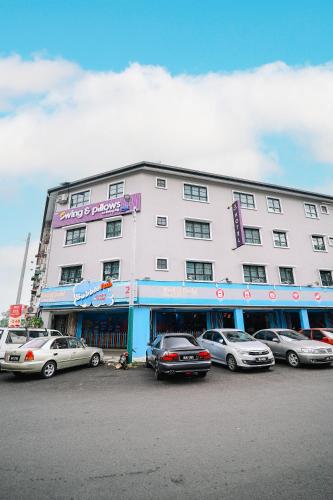 a large white building with cars parked in front of it at Swing & Pillows - Seri Kembangan Selangor in Seri Kembangan