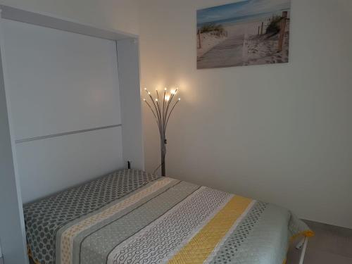 une chambre avec un lit dans une pièce blanche dans l'établissement Grau d'Agde Maison à 1 min plage, au Grau-dʼAgde