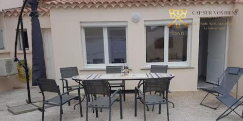 une table et des chaises devant un bâtiment dans l'établissement Grau d'Agde Maison à 1 min plage, au Grau-dʼAgde