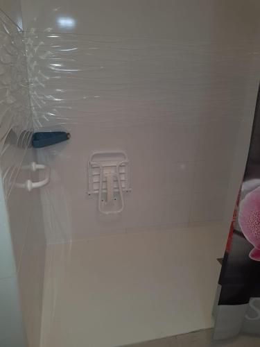 La salle de bains est pourvue d'une douche avec un siège en plastique. dans l'établissement Grau d'Agde Maison à 1 min plage, au Grau-dʼAgde